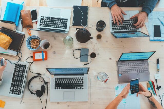 Aerial view of laptops and accessories on wooden table