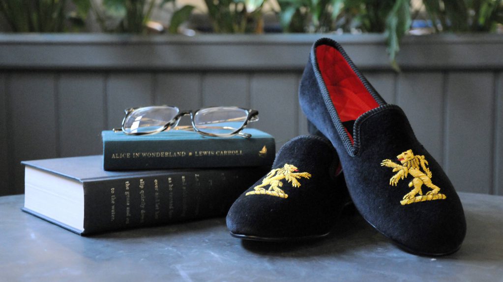 A pair of Broadland Slippers next to a collection of books