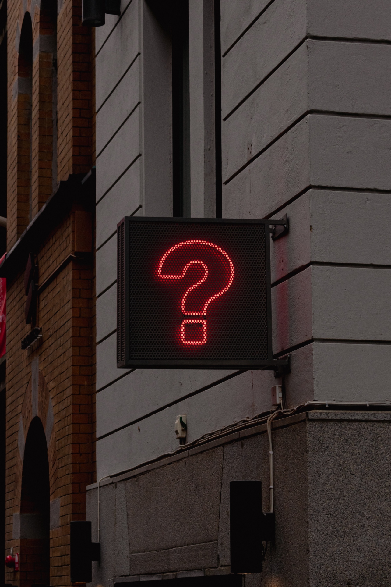 Neon Question Mark Sign in Darkened Street for the Digital Marketing in Plain English - Your Most Asked Questions Blog Post