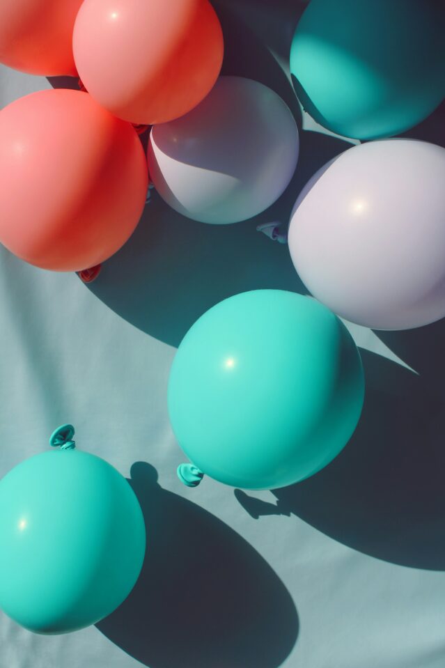 Turquoise, coral and grey balloons.