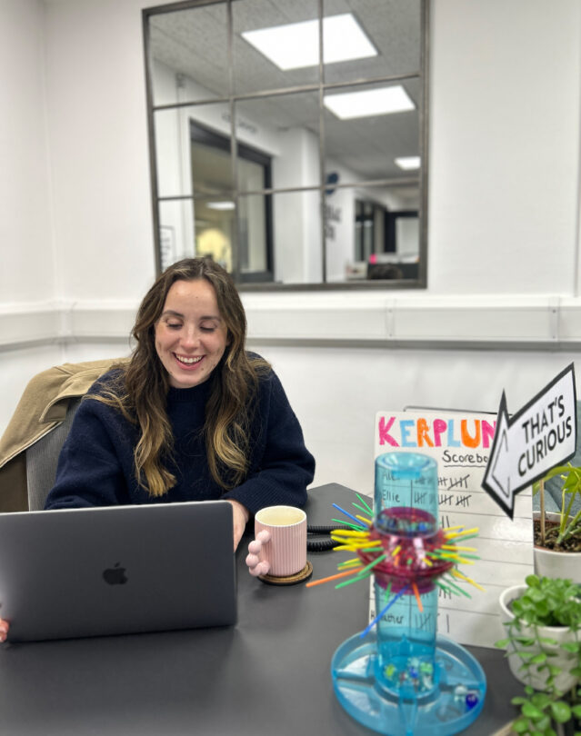 Brunette woman laughing at desk with laptop