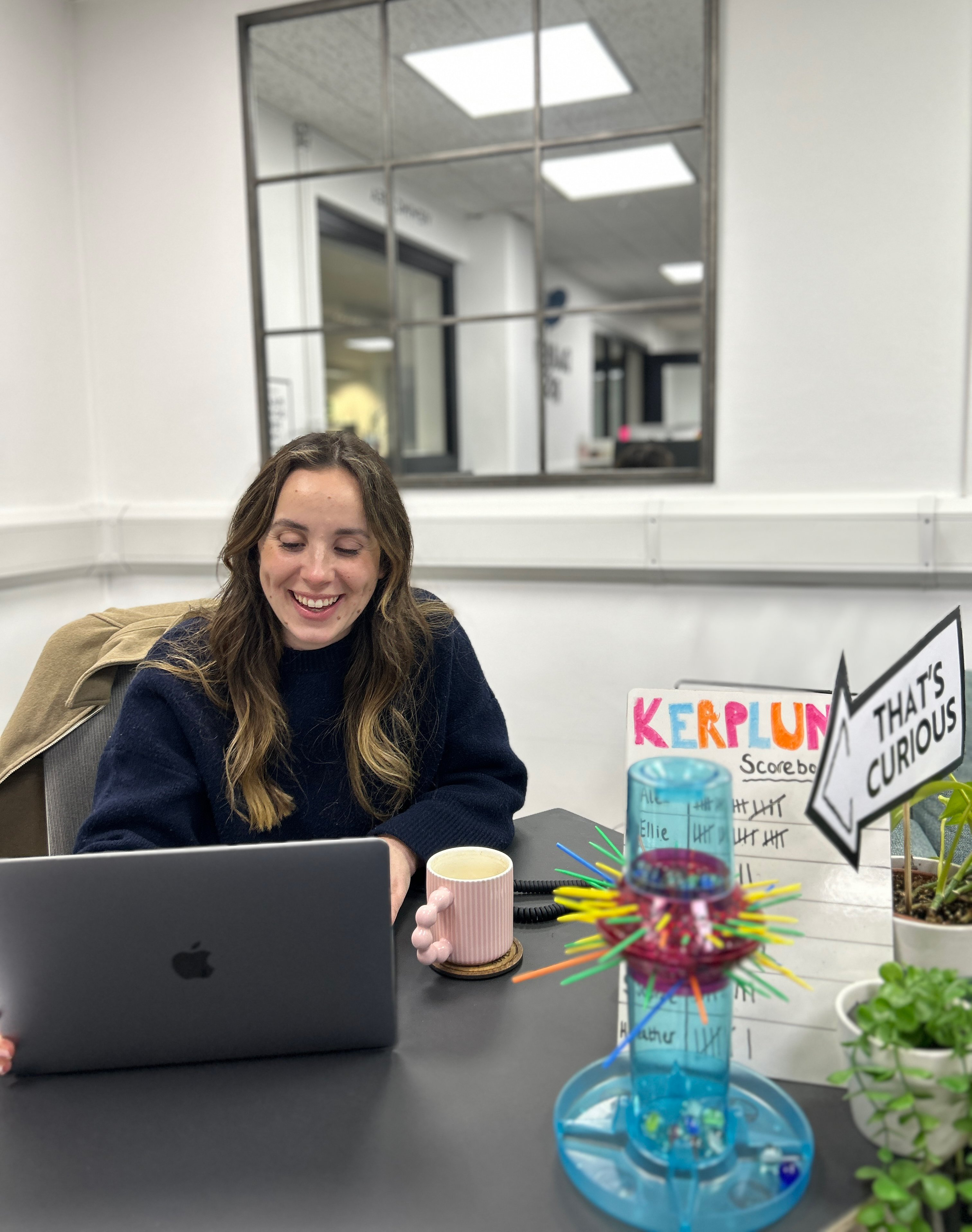 Brunette woman laughing at desk with laptop